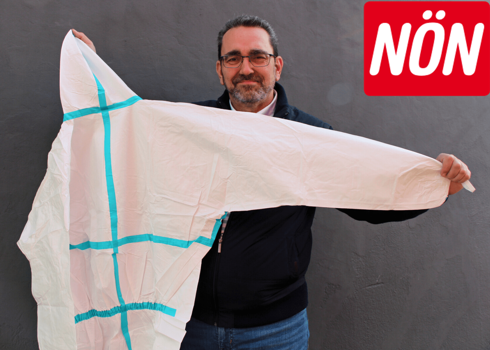 Ein Mann zeigt den Schutzanzug
